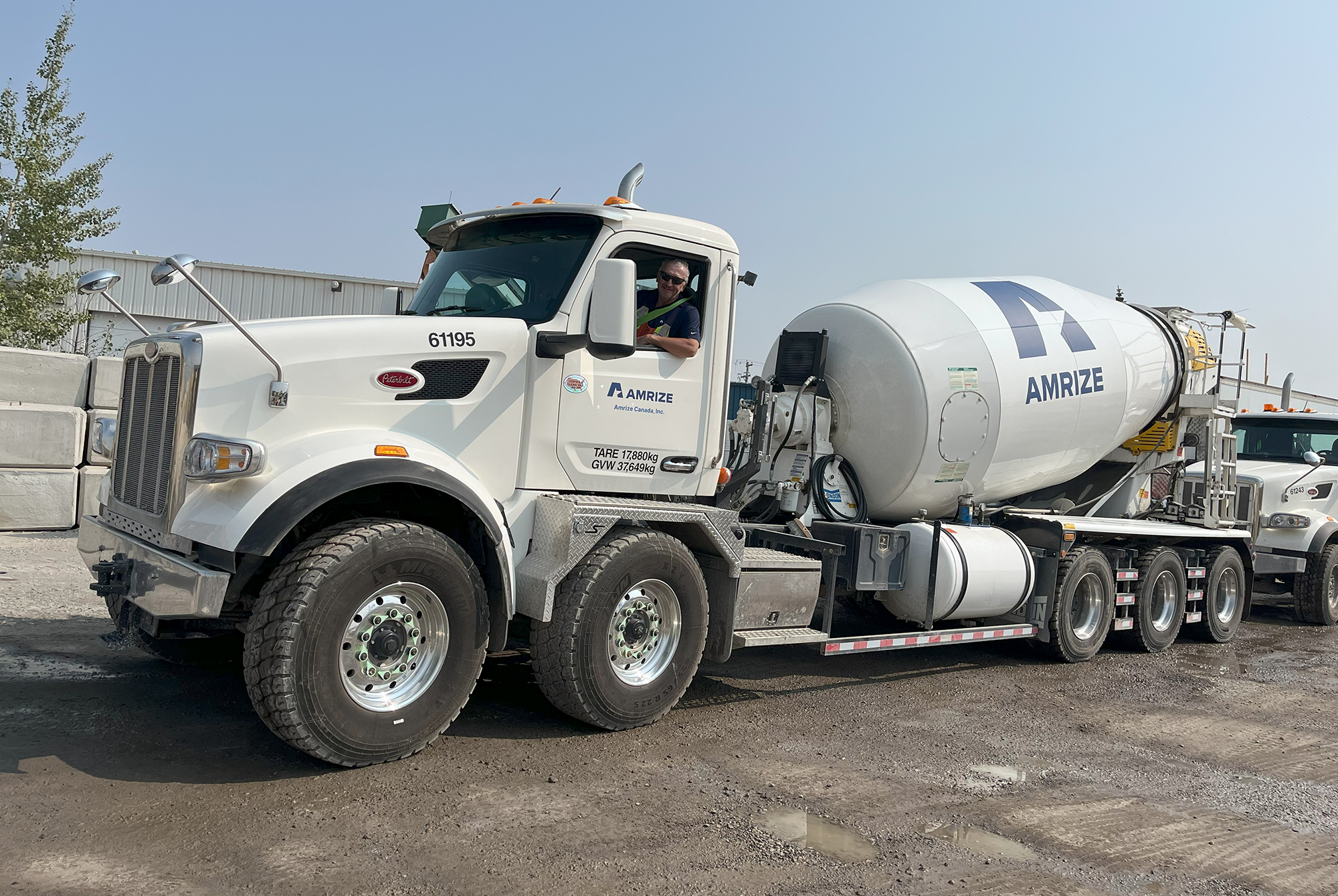 Un gros camion-malaxeur à ciment dans un stationnement sous un ciel bleu