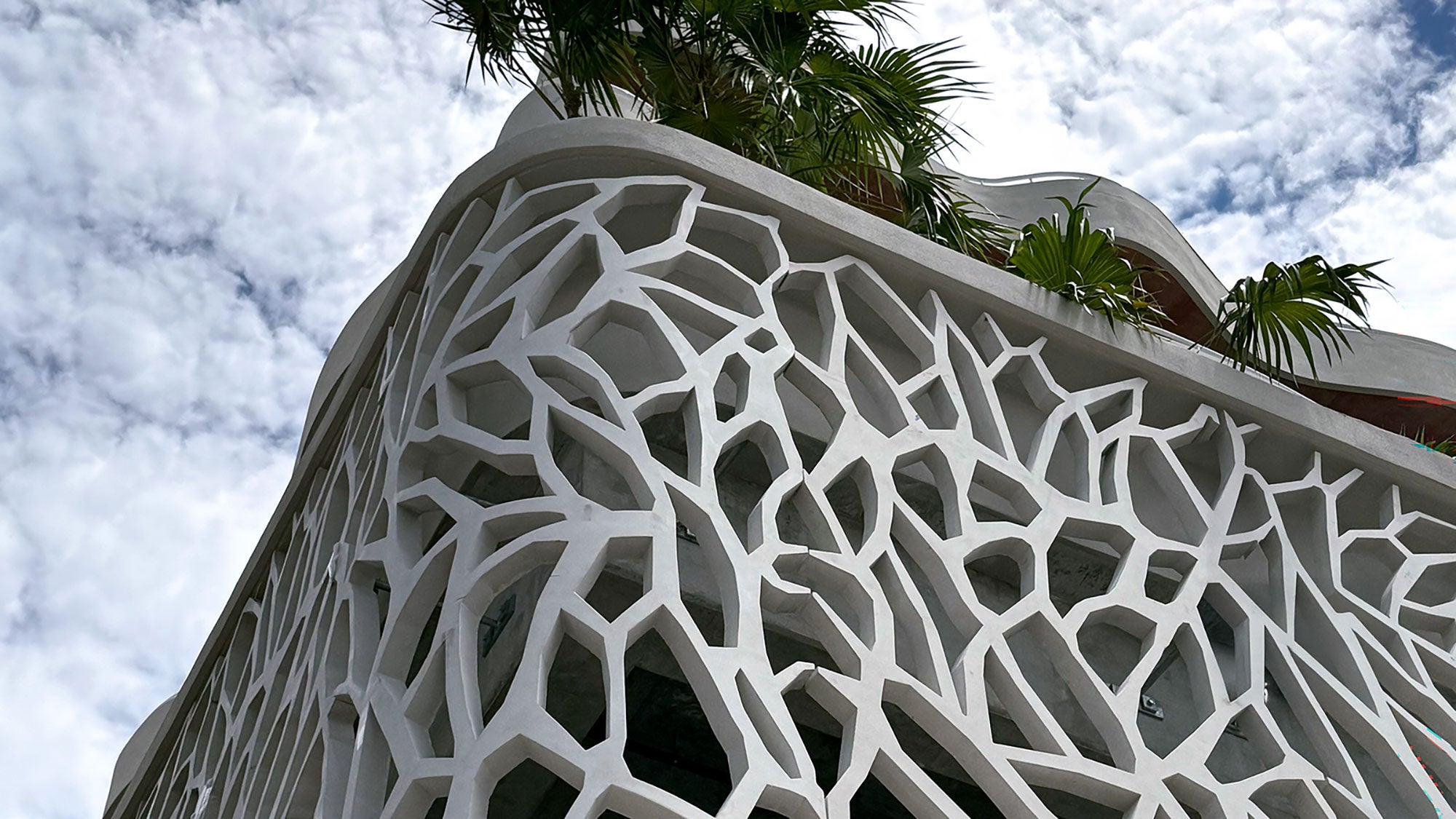 The intricate geometric concrete building facade seen at an angle from below.