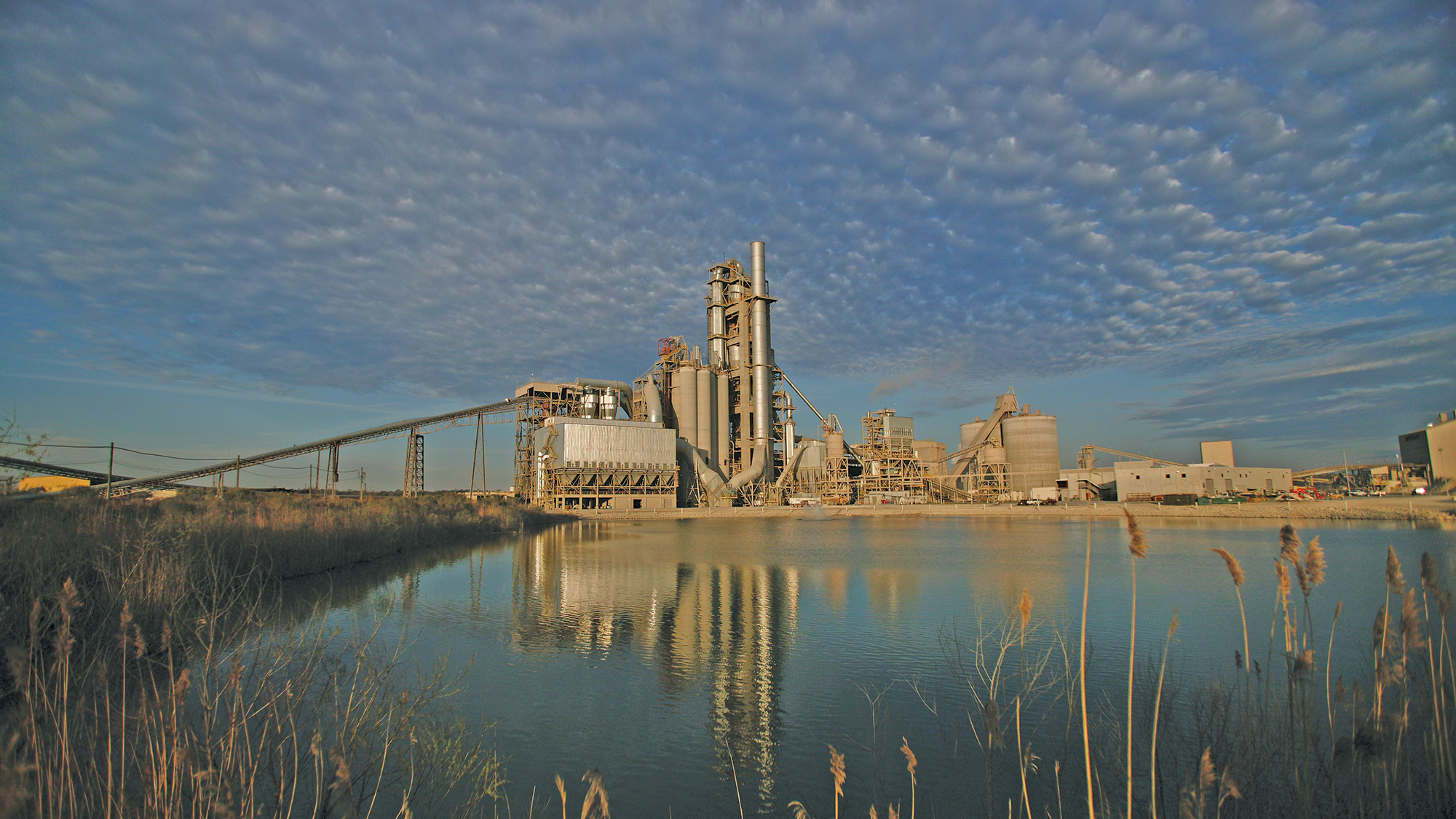 A cement plant viewed from across a marsh
