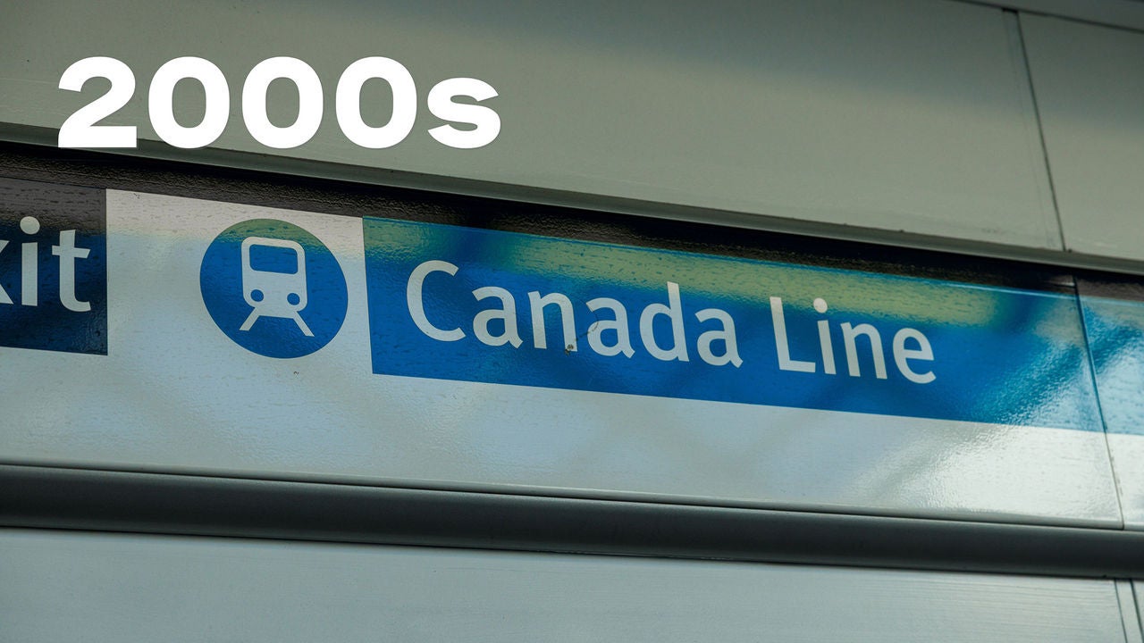 Blue sign reading "Canada Line" with a train icon, indicating a transit route. There is "2000s" in bold white text above.