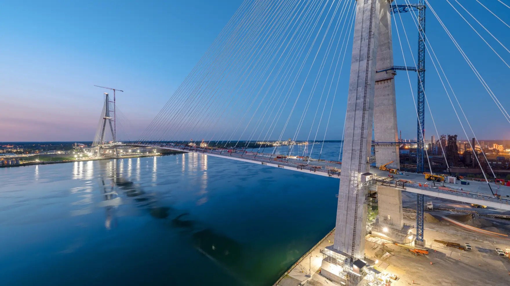 Gordie Howe Bridge, at dusk, illuminated, construction ongoing