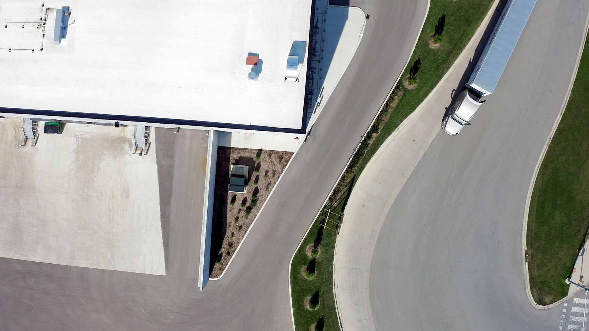 Une vue aérienne d’un centre de données avec un camion circulant sur une route à côté.