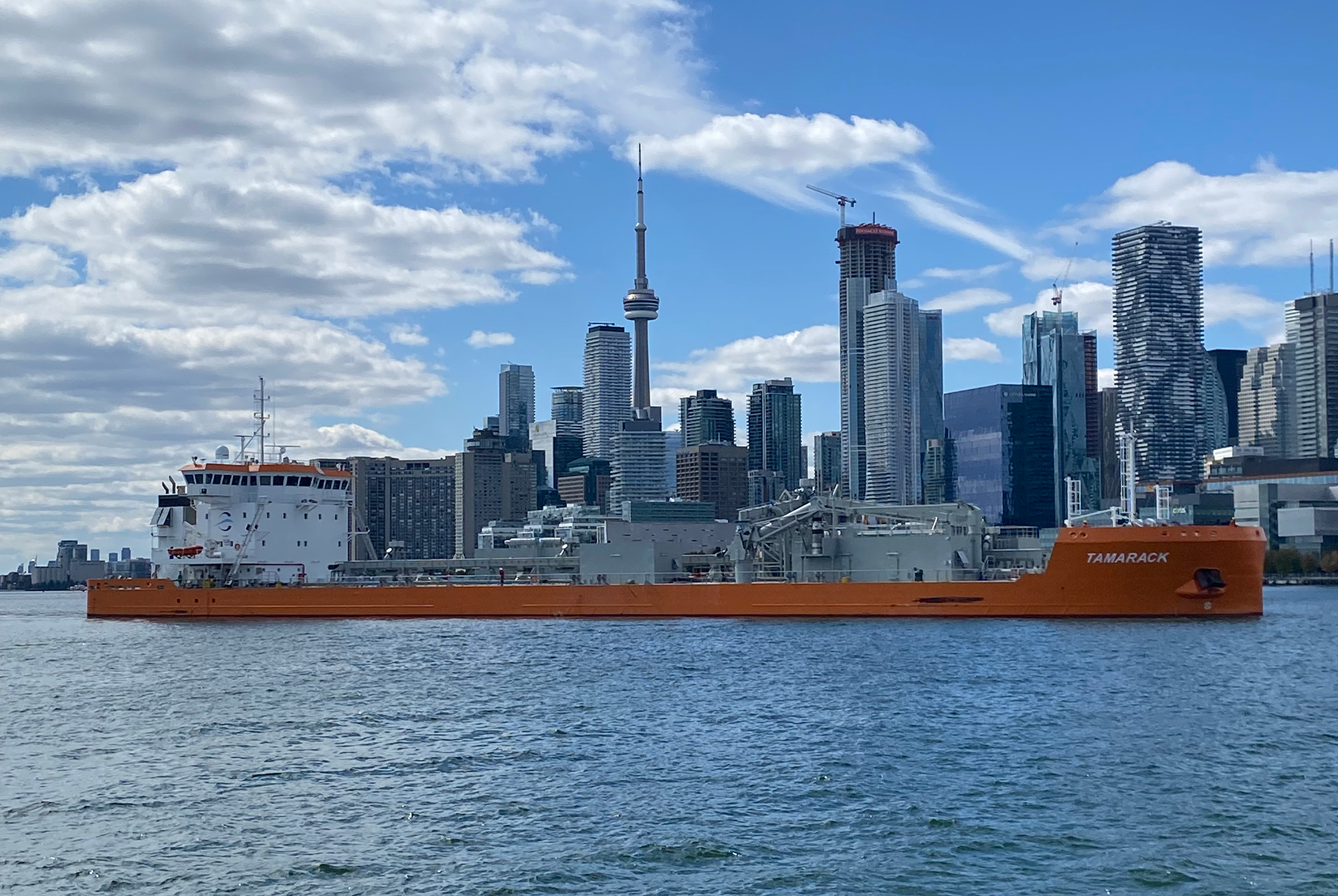 Un grand cargo des Grands Lacs naviguant devant la silhouette de Toronto