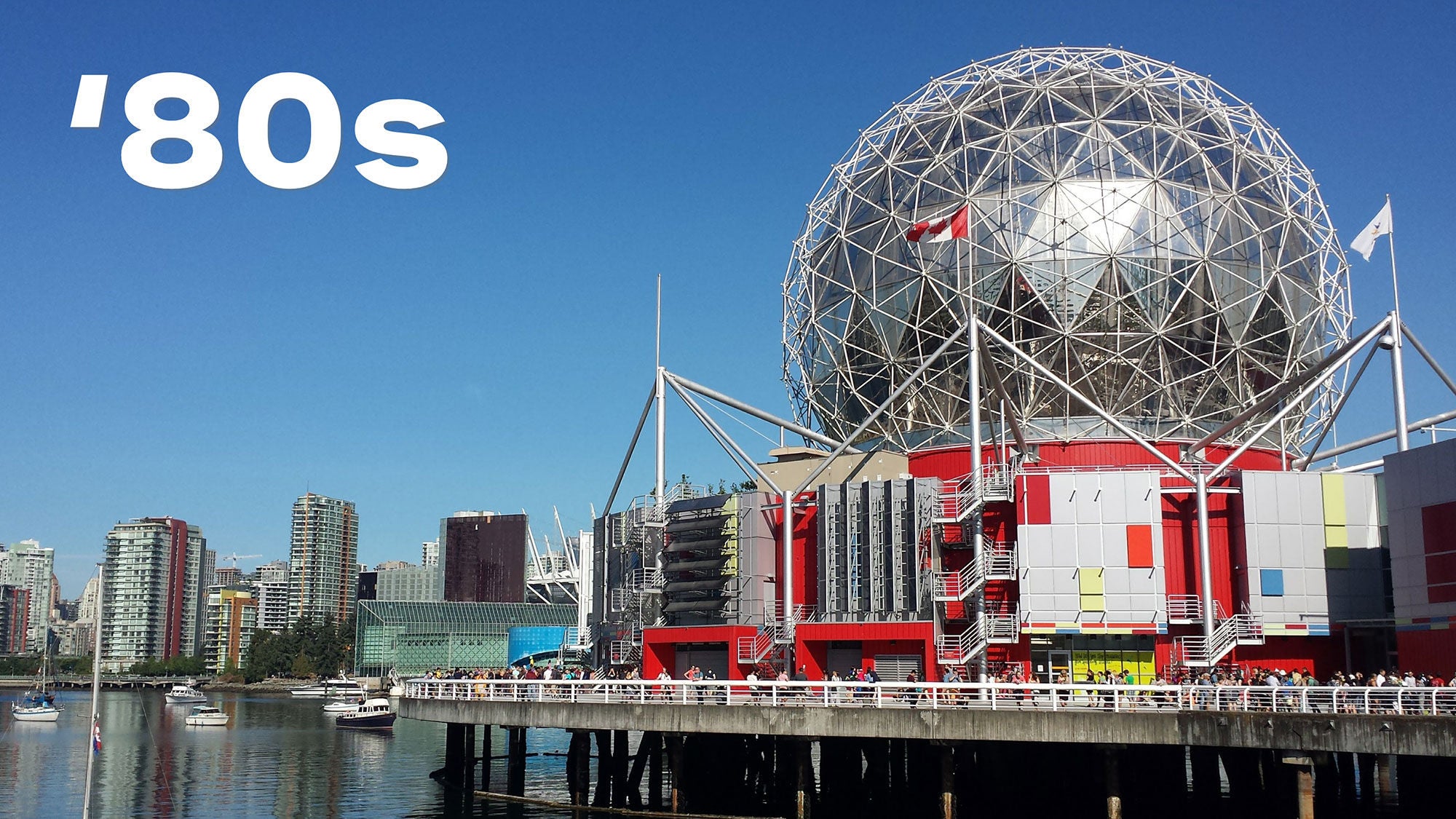 Scenic view of a waterfront city skyline. Prominent geodesic dome, vibrant red accents, and a clear blue sky overhead. There is "’80s" in bold white text above.