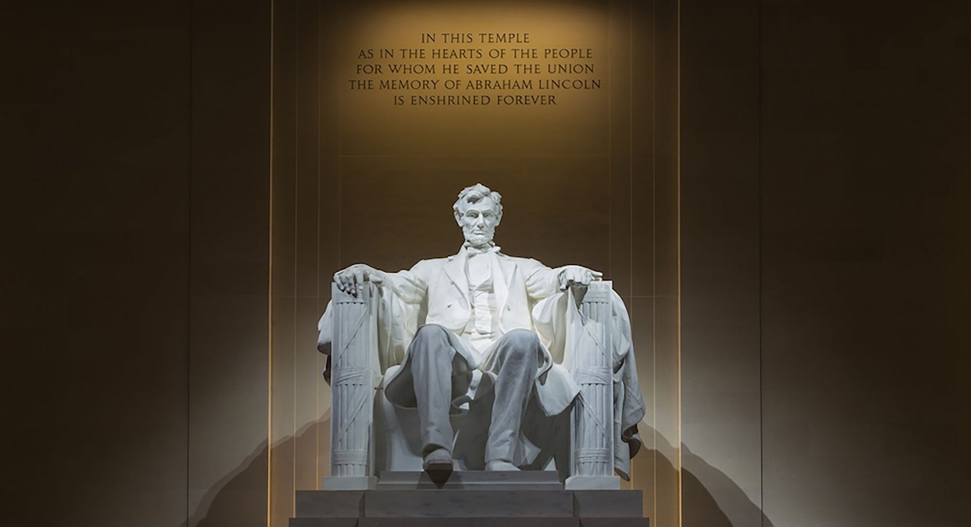 Abraham Lincoln statue, inside the Lincoln Memorial, as a spotlight shines on it. 