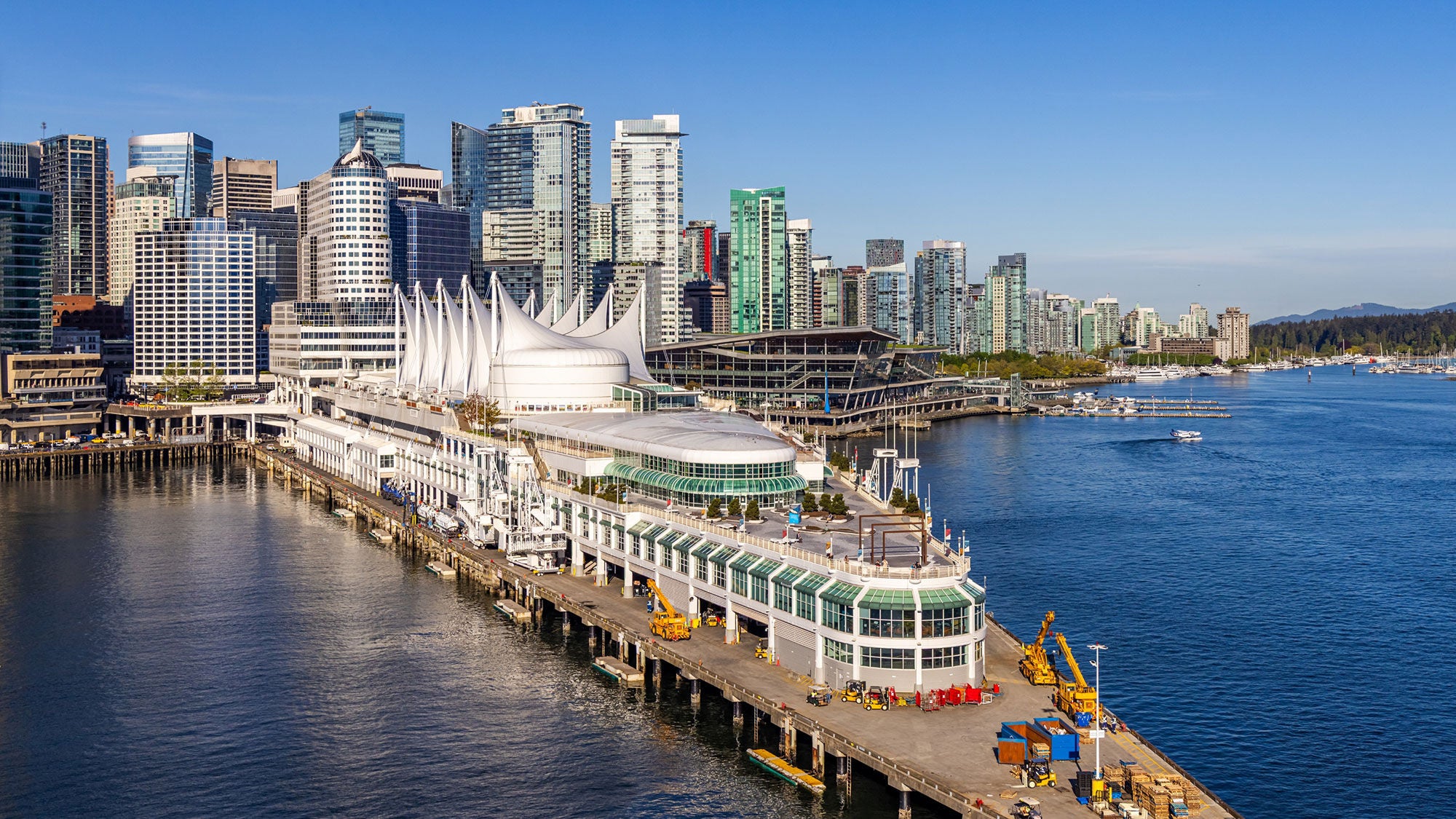 View of a city from the water. Densely packed high-rise buildings line the water. 