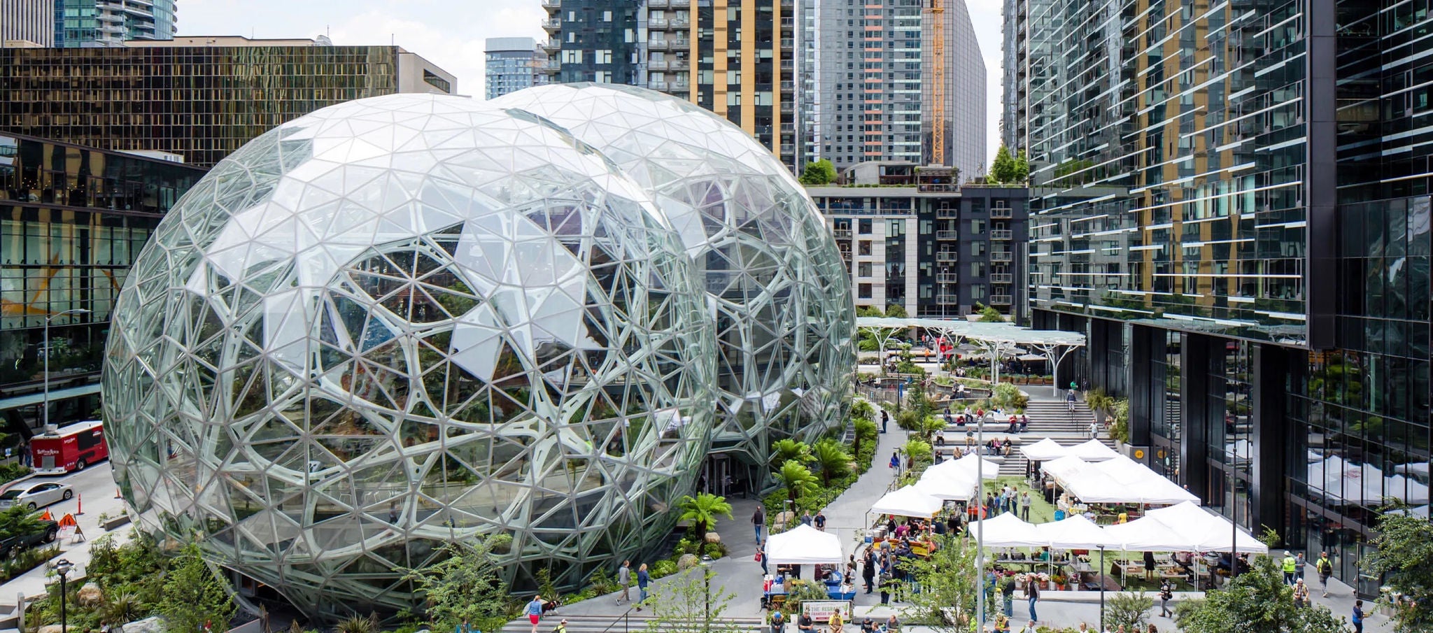 Aerial view of the Spheres and surrounding plaza with market tents and modern high-rise buildings