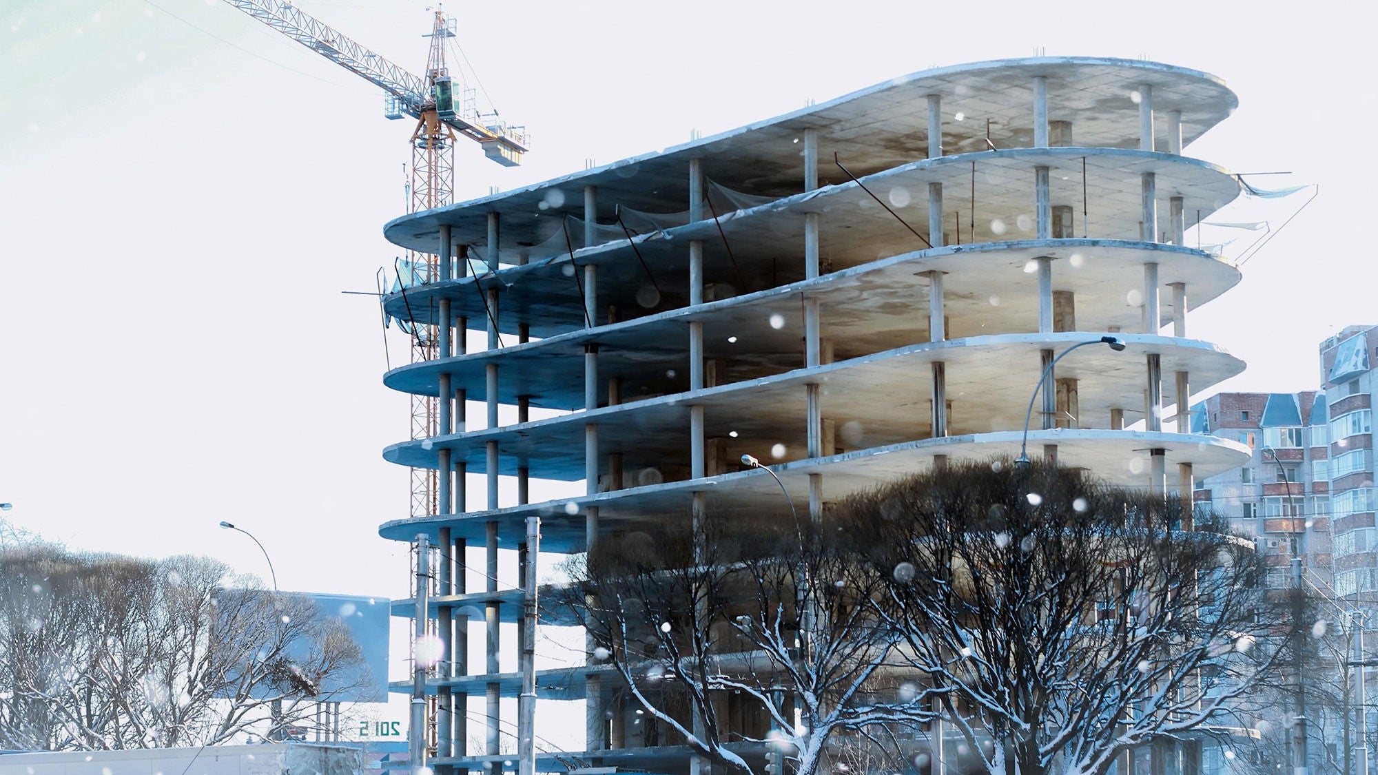 A high-rise under construction in a wintry scene