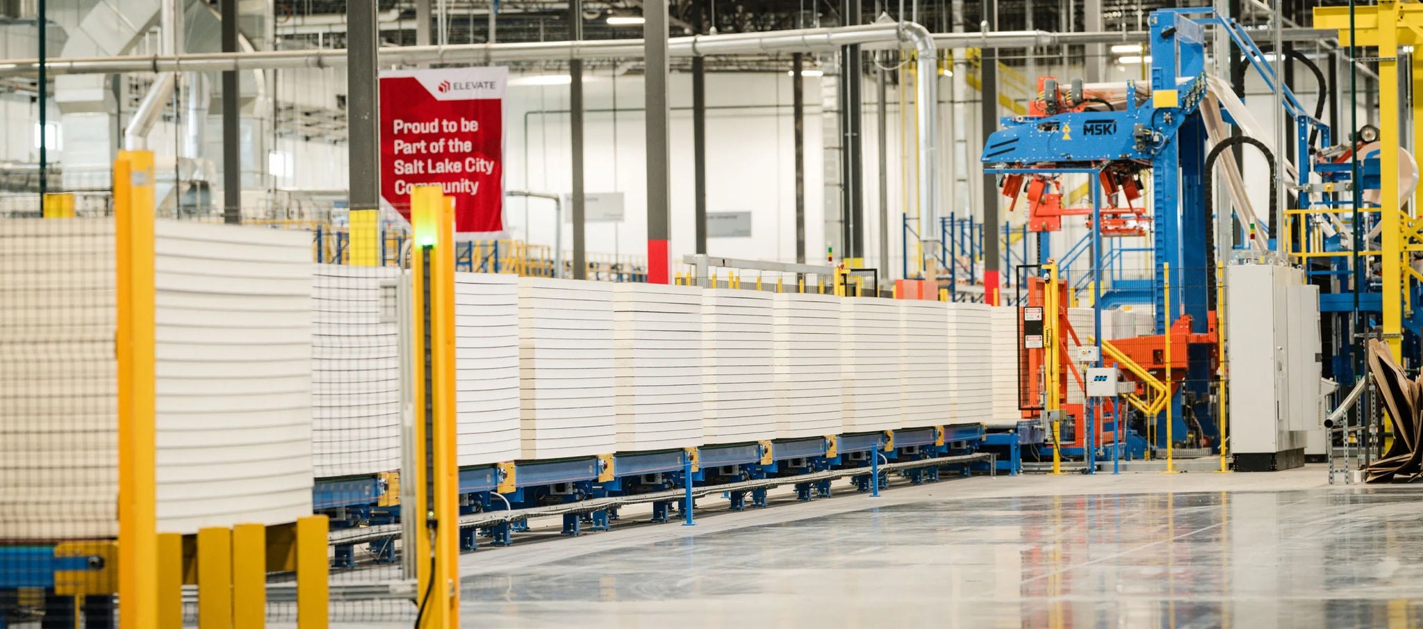  Interior of factory with machinery and stacked materials on conveyor belts