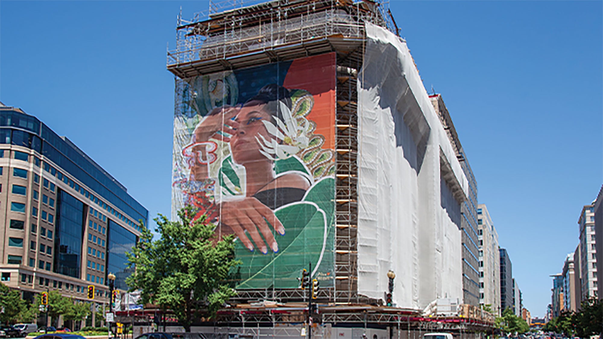 The National Museum of Women in the Arts building, seen during renovations, with a striking mural of a woman on the face of the building. 