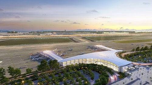 A rendering of a large airport terminal with airport runways behind it at dusk